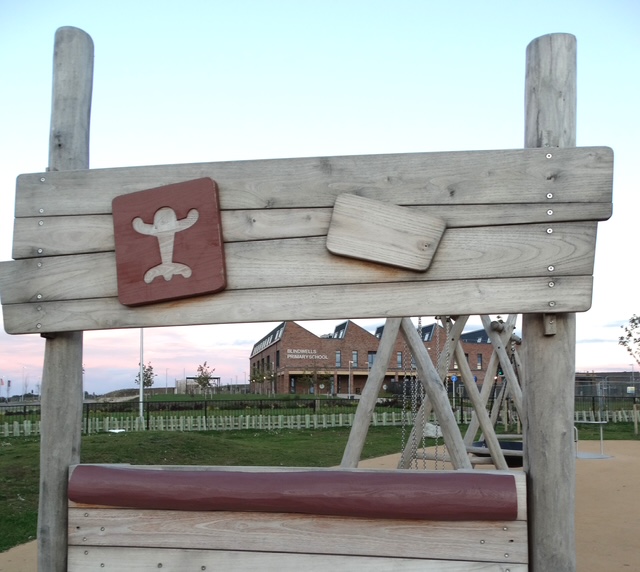 Wooden play frame with the school visible through it